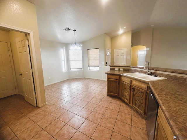 kitchen featuring light tile patterned floors, dark countertops, vaulted ceiling, a sink, and dishwasher