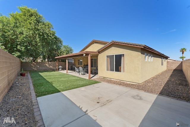 back of house featuring a yard and a patio