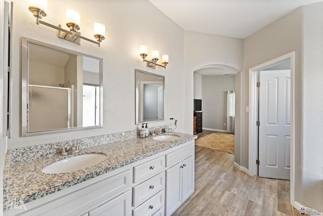 bathroom with vanity, wood-type flooring, and a shower with shower door