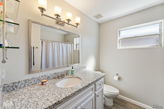 bathroom featuring vanity, hardwood / wood-style flooring, and toilet