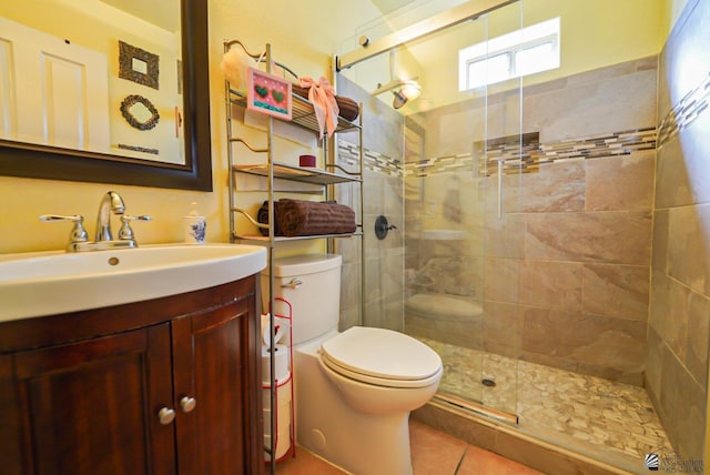 bathroom featuring toilet, tile patterned flooring, an enclosed shower, and vanity