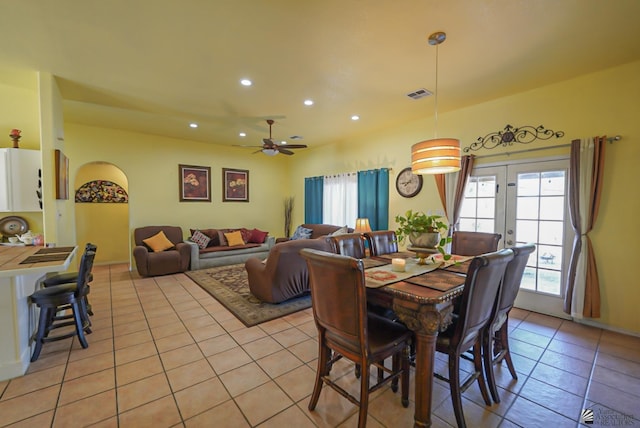 tiled dining room featuring ceiling fan and french doors