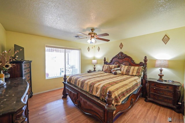 bedroom featuring ceiling fan, a textured ceiling, and light wood-type flooring