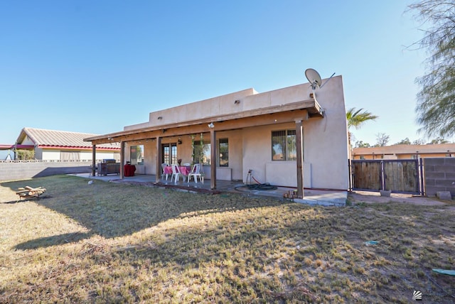 rear view of property with a patio and a yard