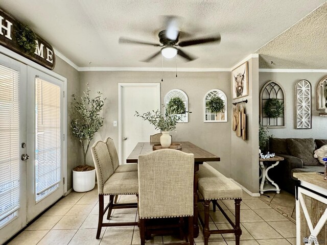 tiled dining area featuring ceiling fan, plenty of natural light, a textured ceiling, and ornamental molding