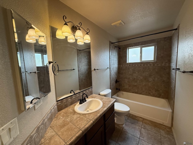 full bathroom with toilet, vanity, tiled shower / bath combo, and a healthy amount of sunlight