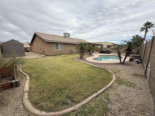 view of yard featuring a fenced in pool and a storage shed