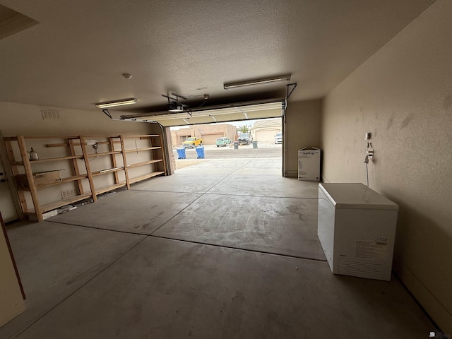 garage with a garage door opener and fridge