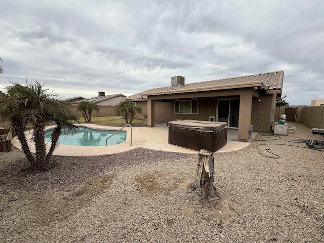 view of pool featuring a hot tub, cooling unit, and a patio area