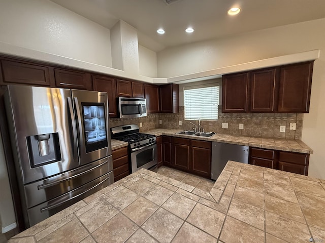 kitchen featuring tasteful backsplash, high vaulted ceiling, appliances with stainless steel finishes, dark brown cabinets, and sink