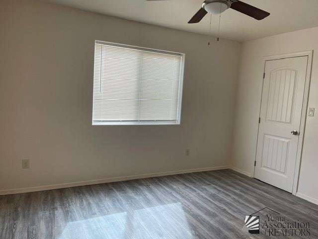 unfurnished room with ceiling fan and dark hardwood / wood-style flooring