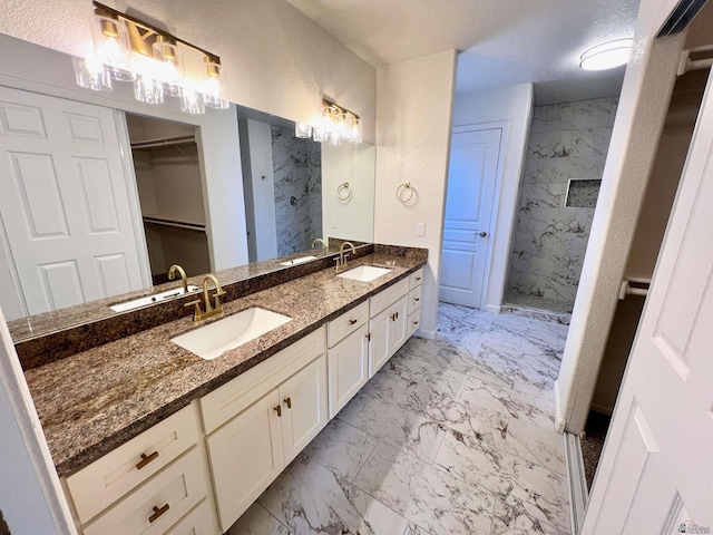 bathroom with vanity, a textured ceiling, and a tile shower