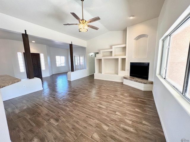 unfurnished living room featuring vaulted ceiling, dark hardwood / wood-style floors, and ceiling fan