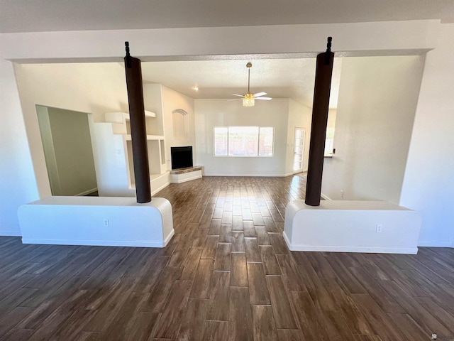 unfurnished living room featuring dark wood-type flooring, ceiling fan, and vaulted ceiling