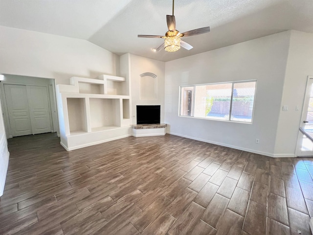 unfurnished living room featuring vaulted ceiling, dark hardwood / wood-style floors, and ceiling fan