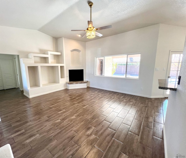 unfurnished living room with a healthy amount of sunlight, lofted ceiling, and dark wood-type flooring