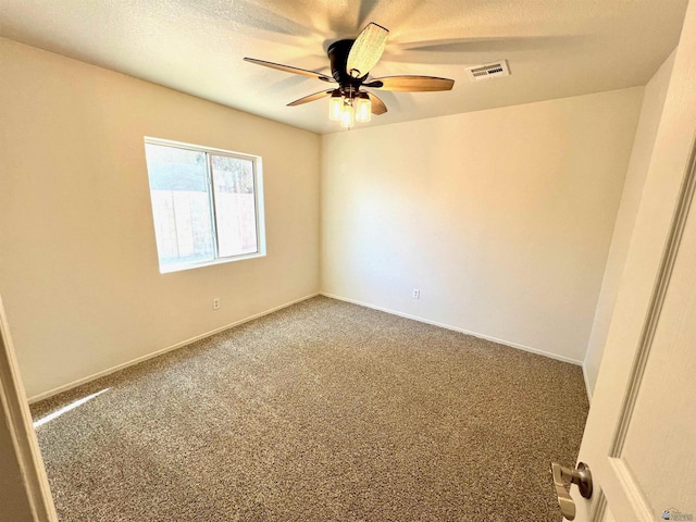 spare room with ceiling fan, carpet floors, and a textured ceiling