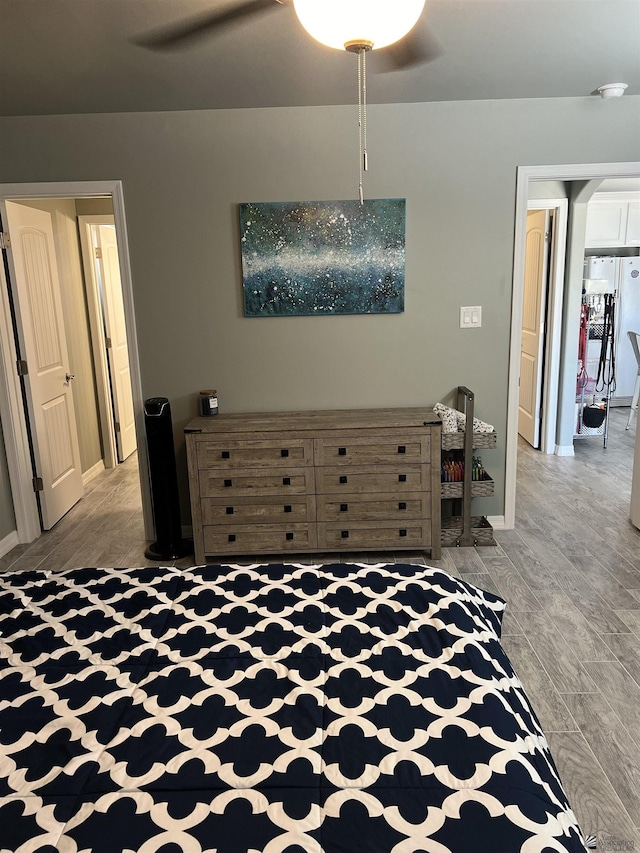 unfurnished bedroom featuring hardwood / wood-style floors, ceiling fan, and white fridge