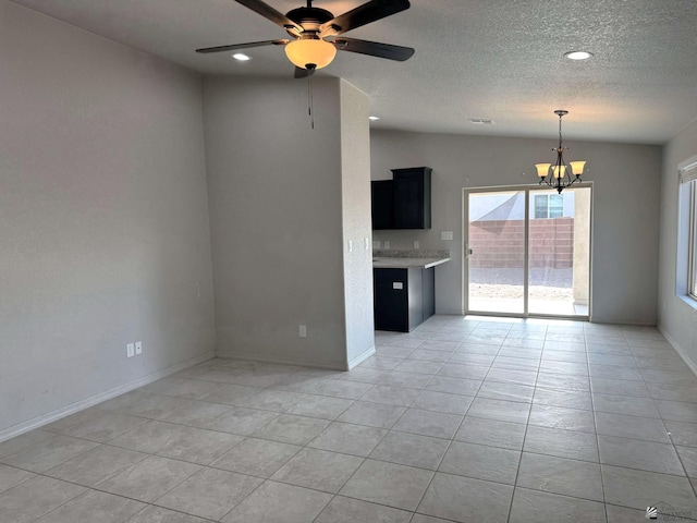 unfurnished living room featuring vaulted ceiling, ceiling fan with notable chandelier, a textured ceiling, and light tile patterned flooring