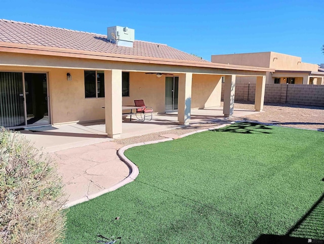 rear view of house featuring a patio, central air condition unit, fence, a lawn, and stucco siding