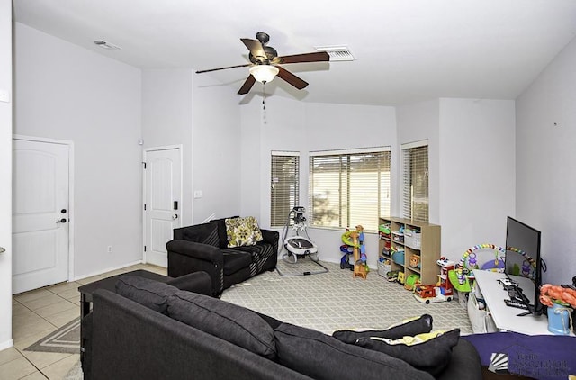 living area with light tile patterned floors, baseboards, visible vents, and a ceiling fan