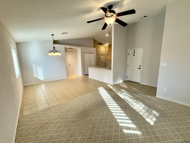 tiled dining area with lofted ceiling and ceiling fan with notable chandelier