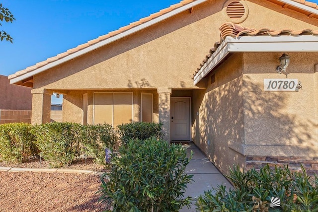 property entrance featuring stucco siding and a tiled roof