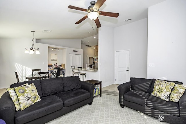 living area featuring lofted ceiling, ceiling fan, and visible vents