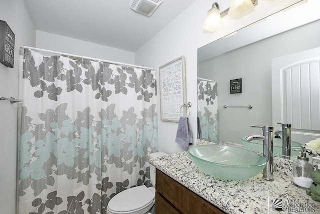 bathroom featuring toilet, visible vents, and vanity