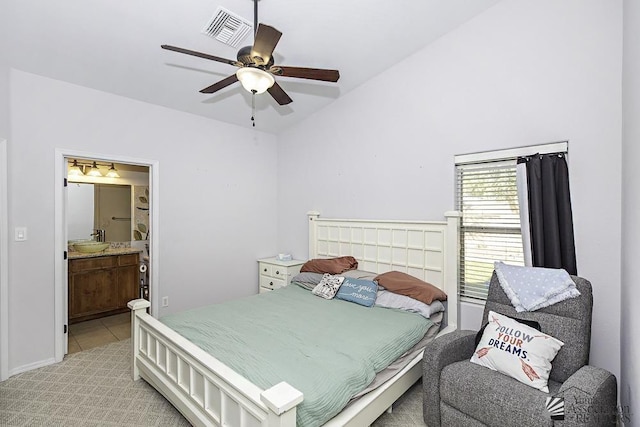 bedroom with visible vents, a ceiling fan, light tile patterned flooring, vaulted ceiling, and ensuite bath