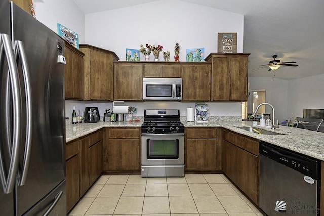 kitchen featuring light stone counters, sink, appliances with stainless steel finishes, and dark brown cabinets