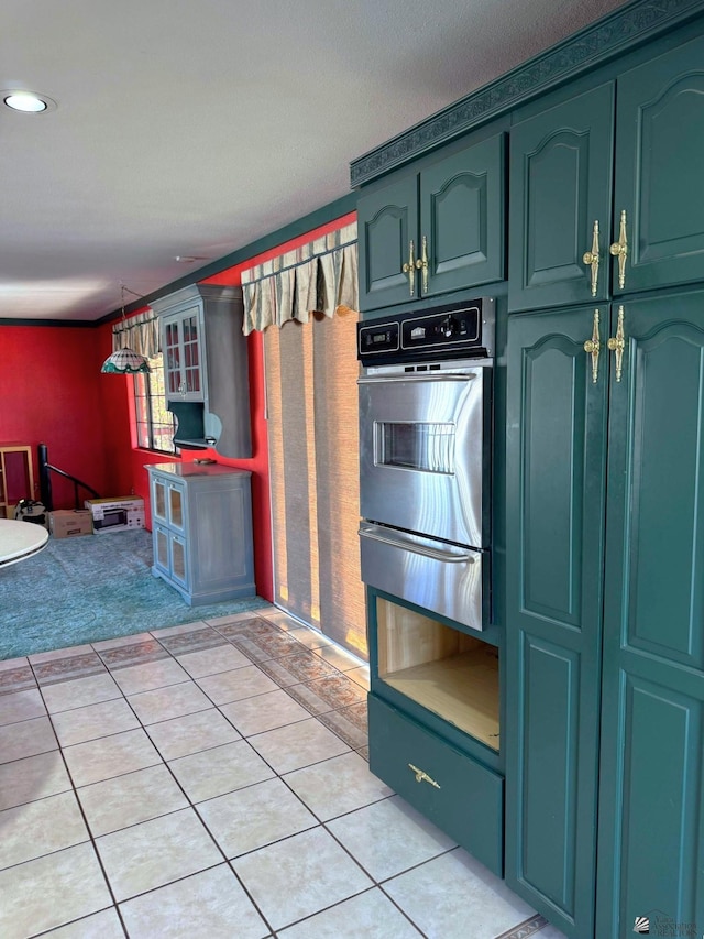 kitchen with pendant lighting, wall oven, light colored carpet, and green cabinets