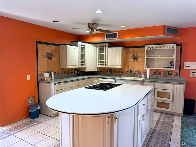 kitchen featuring light tile patterned floors, a center island, black gas cooktop, and sink