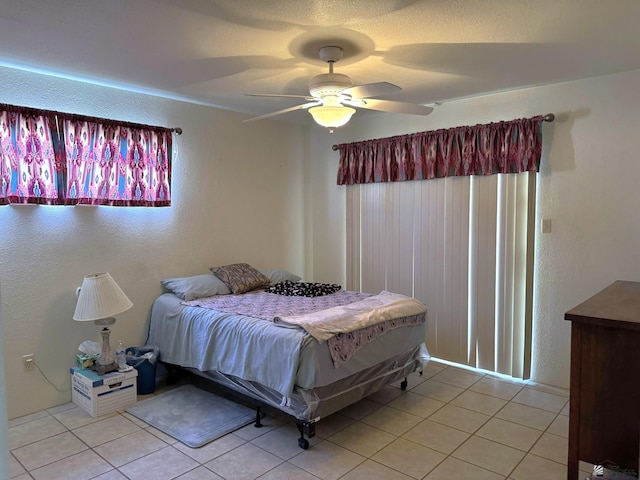 tiled bedroom featuring ceiling fan