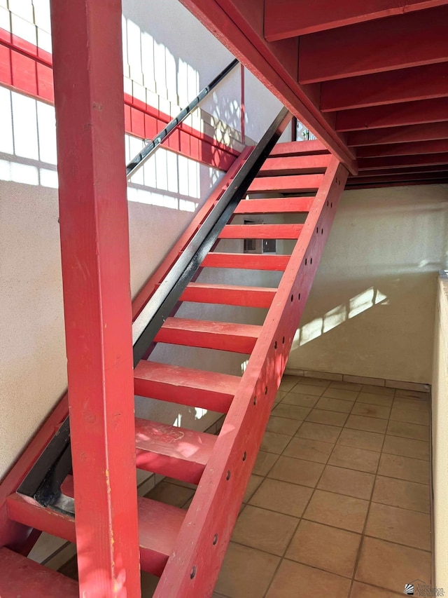 stairway featuring tile patterned floors and plenty of natural light