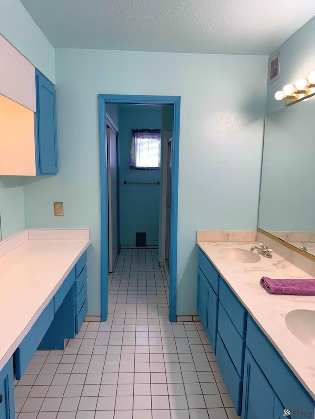 bathroom featuring tile patterned floors, vanity, and a textured ceiling