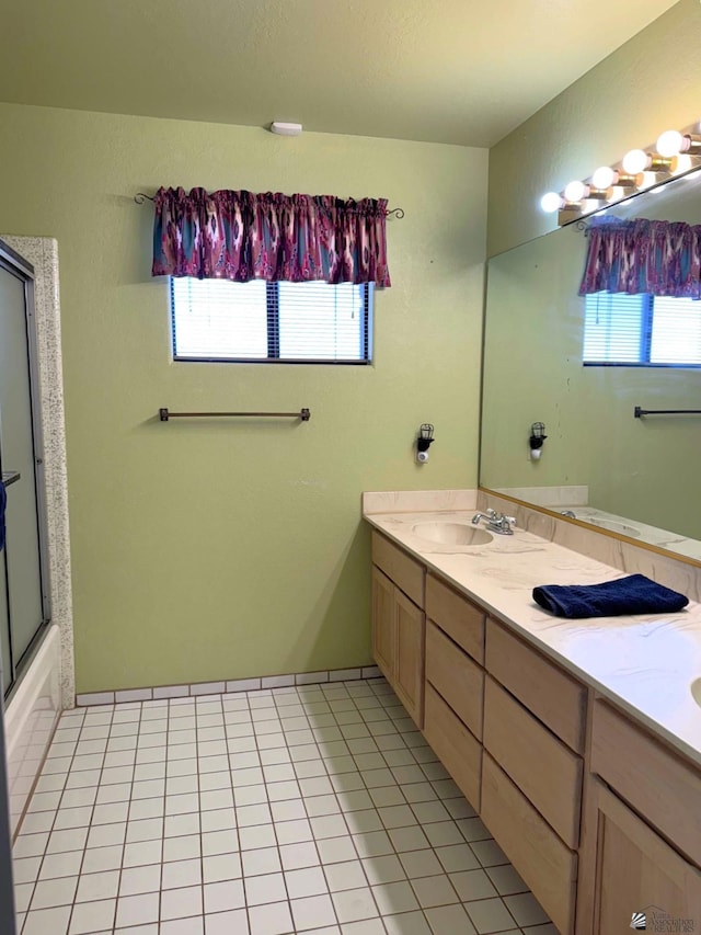 bathroom featuring tile patterned flooring, vanity, and combined bath / shower with glass door