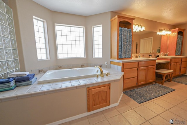 bathroom with vanity, tile patterned floors, a bath, and a textured ceiling