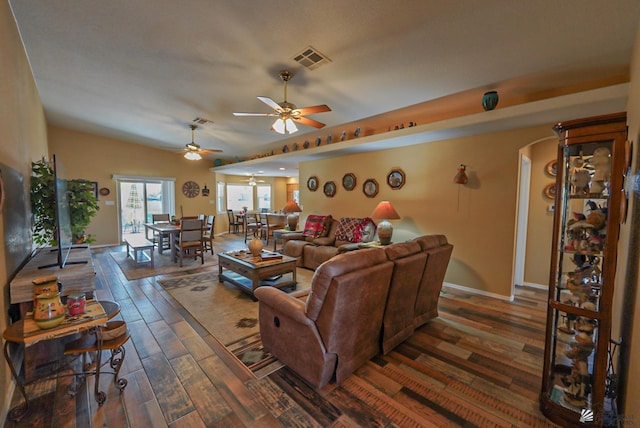 living room with visible vents, a ceiling fan, wood finished floors, arched walkways, and baseboards