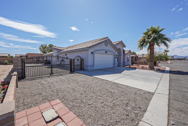 view of home's exterior with a fenced front yard, stucco siding, a garage, driveway, and a gate