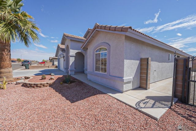 view of front of house with stucco siding and a tile roof