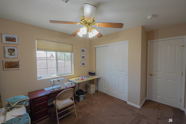 carpeted office space with a ceiling fan and baseboards