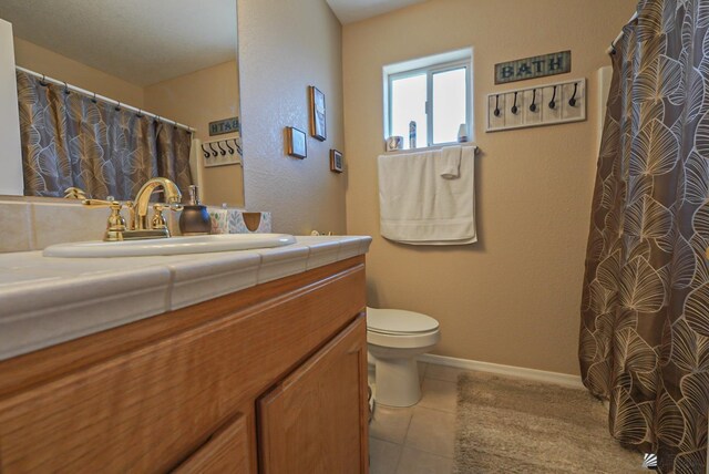 bathroom with tile patterned floors, baseboards, toilet, and vanity