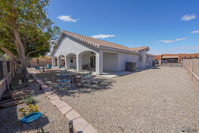 rear view of house featuring a fenced backyard, stucco siding, a tile roof, and a patio