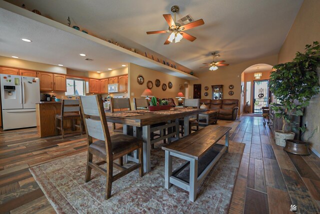 dining area with visible vents, arched walkways, a healthy amount of sunlight, and wood finished floors