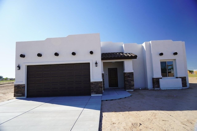 pueblo revival-style home with a garage