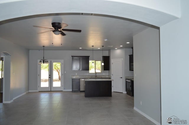 kitchen with decorative light fixtures, a kitchen island, sink, and ceiling fan with notable chandelier