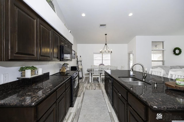 kitchen with sink, hanging light fixtures, dark brown cabinetry, black appliances, and dark stone counters