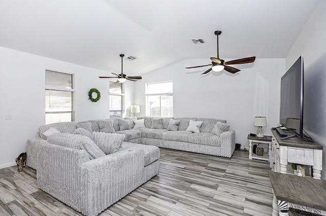 living room with vaulted ceiling, ceiling fan, and light wood-type flooring