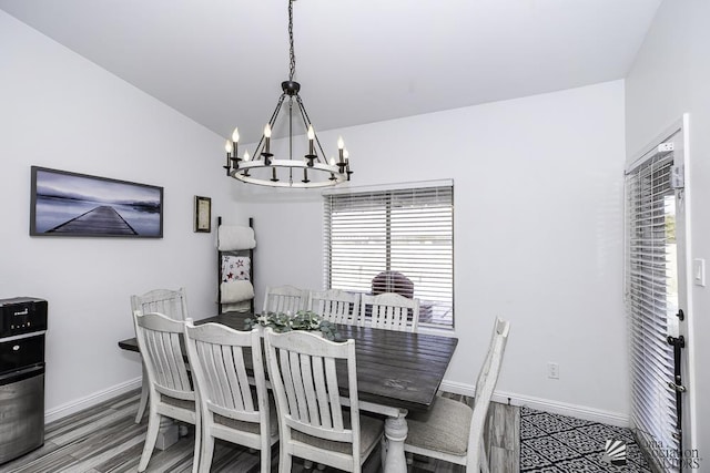 dining area featuring an inviting chandelier, hardwood / wood-style flooring, and lofted ceiling